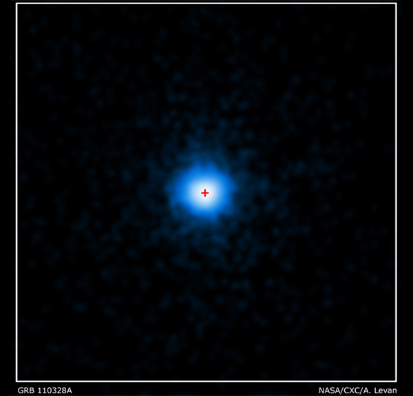 Рис. 4. Аппаратура обсерватории «Чандра» показала, что загадочный гамма-всплеск возник в самом центре (отмечен красным крестиком) галактики. Снимок далекой галактики сделан телескопом «Хаббл». Изображение из пресс-релиза НАСА: NASA/CXC/ Warwick/A. Levan