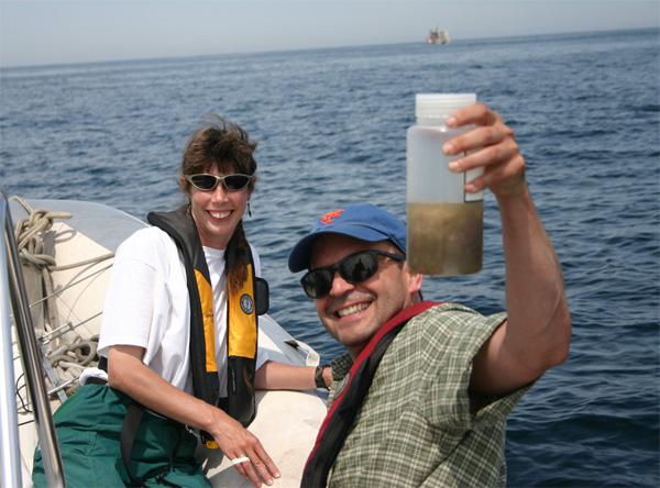 Рис. 3. Исследователи в заливе Мэн. В руках одного из авторов обсуждаемой работы, Джо Романа, банка с фекалиями кита. Фото: © Jeremy Winn с сайта uvm.edu