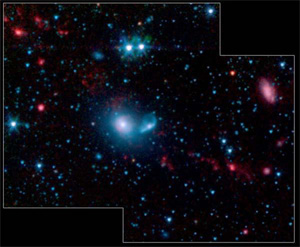 Примерно 15 карликовых галактик (красный цвет) образовались вдоль двух дуг, находящихся на расстоянии нескольких тысяч световых лет от двух крупных галактик, вместе называемых NGC 5291 (в центре). Фото NASA/JPL-Caltech/Cornell Univ с сайта www.newscientistspace.com