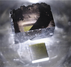Монокристалл алмаза (вверху), полученный методом химического осаждения пара на шести гранях алмазного субстрата (внизу) размером 4 х 4 х 1,5 мм (фото с сайта www.carnegieinstitution.org)